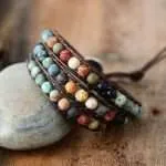 Pulsera hecha a mano de jaspe, ónix y cuerda de cuero. Medallón en forma de corazón.