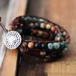Pulsera hecha a mano de jaspe, ónix y cuerda de cuero. Medallón en forma de corazón.